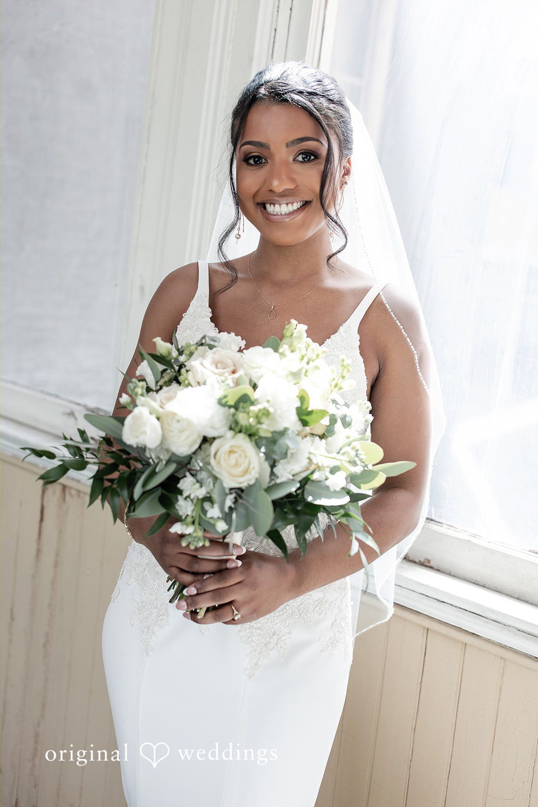 Sydney + Ty Bride smiling while holding her wedding bouquet