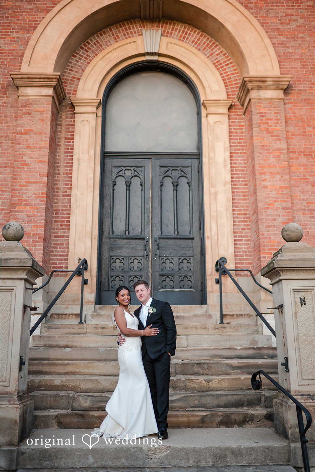 Sydney + Ty Wide portrait of the bride and groom in front of Bell Event Centre
