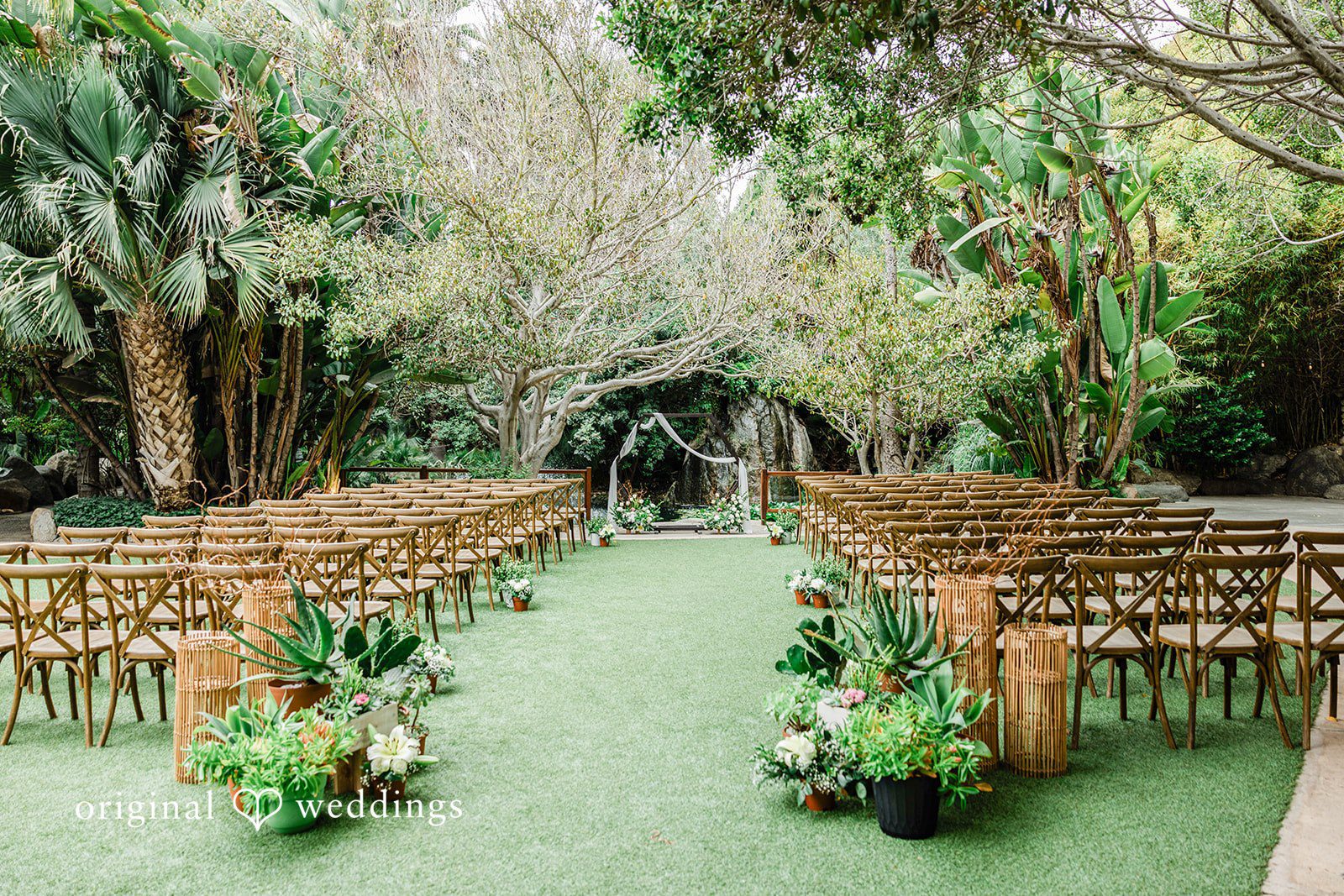 Mae + Nicholas Ceremony setup at Botanica surrounded by lush tropical greenery.