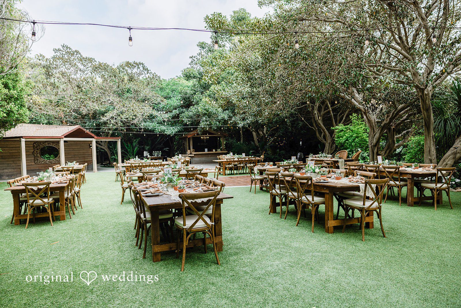 Mae + Nicholas Outdoor reception setup with rustic tables and garden décor at Botanica.