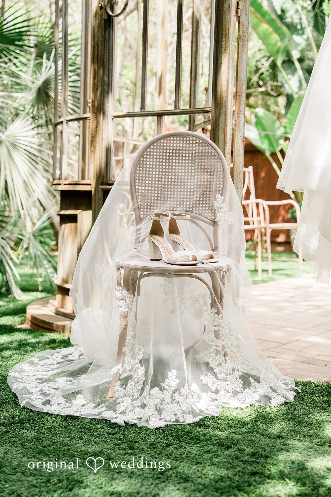 Mae + Nicholas Bridal shoes displayed on a chair draped with veil at Botanica.