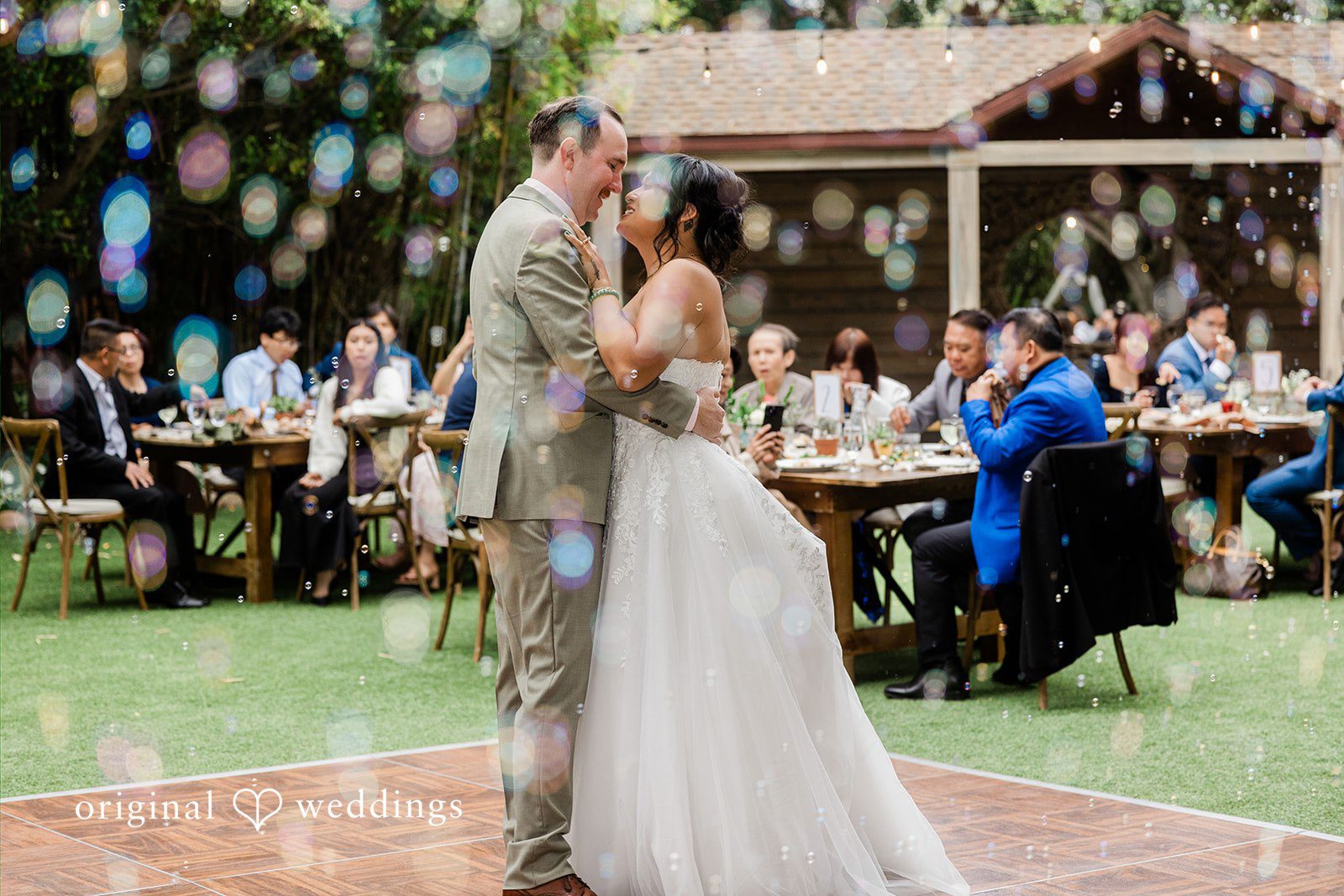 Mae + Nicholas The couple shares a romantic first dance surrounded by guests and floating bubbles