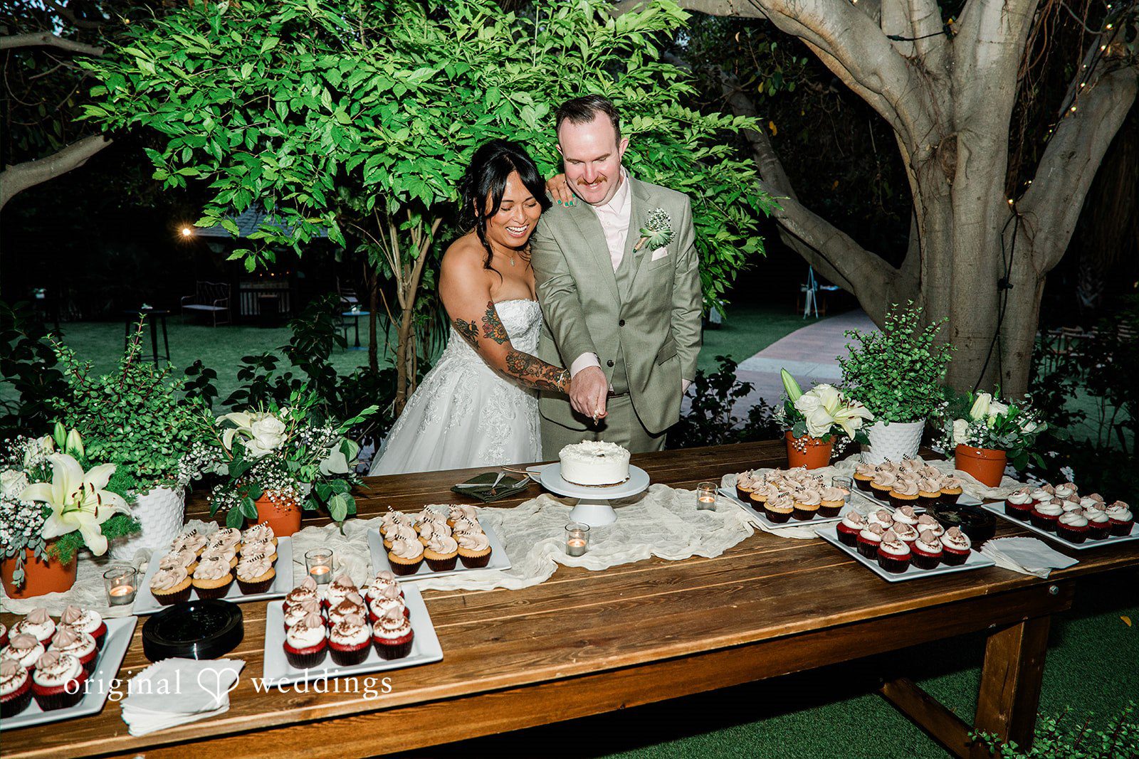 Mae + Nicholas Couple cuts their wedding cake surrounded by elegant reception details