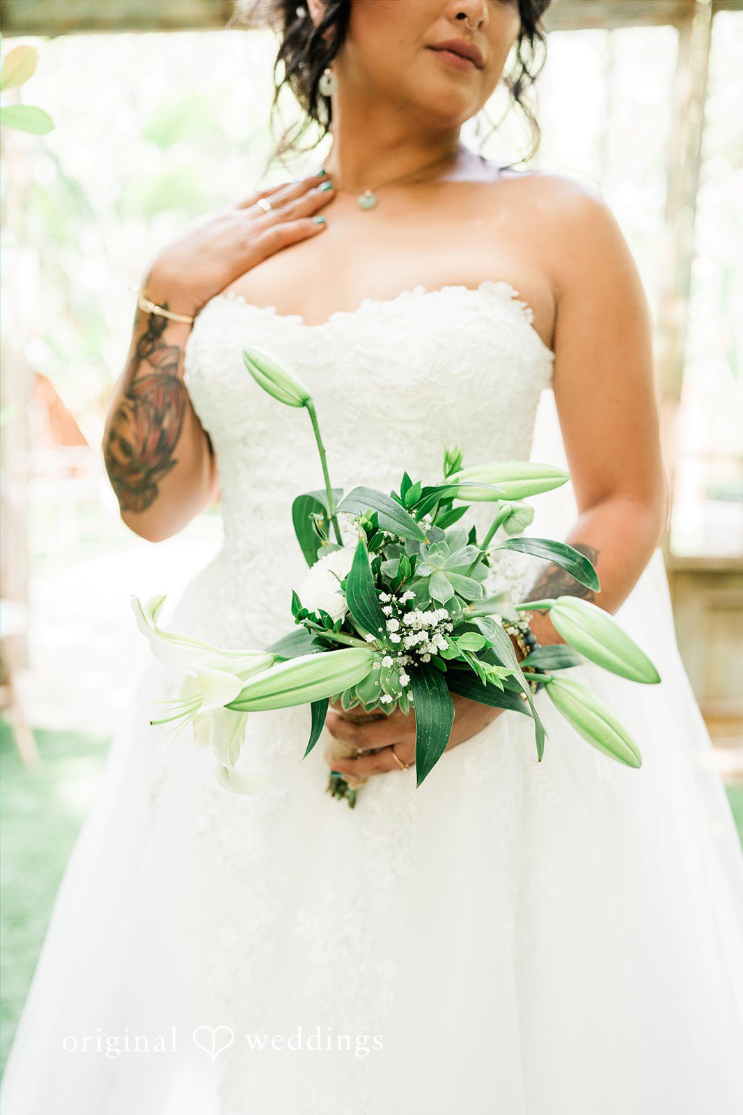 Mae + Nicholas Bride holding a fresh white lily bouquet in a soft portrait at Botanica.