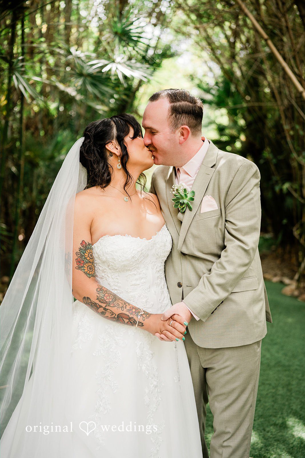 Mae + Nicholas Bride and groom sharing a kiss along Botanica’s tropical garden pathway