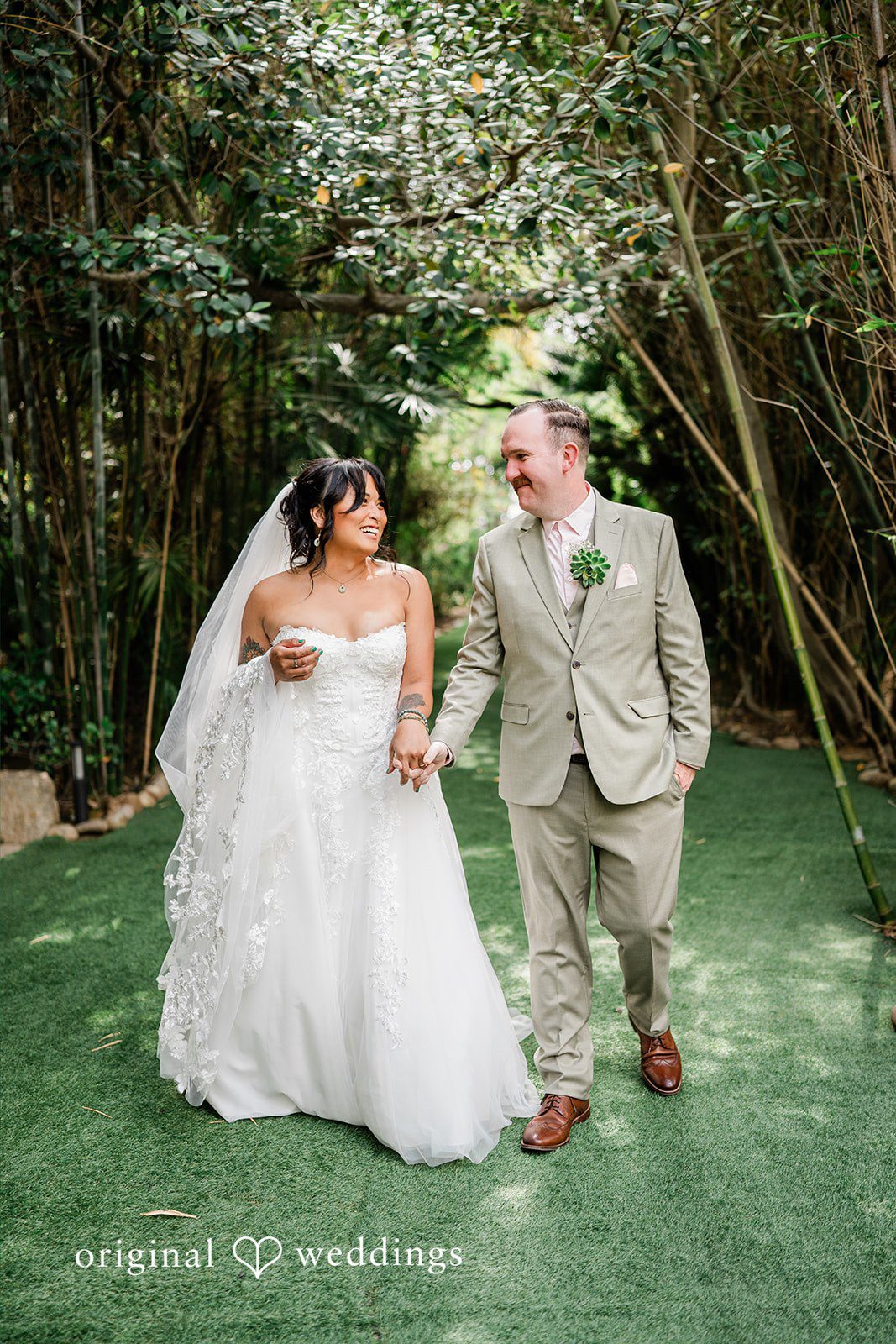 Mae + Nicholas Bride and groom posing beneath Botanica’s lush garden