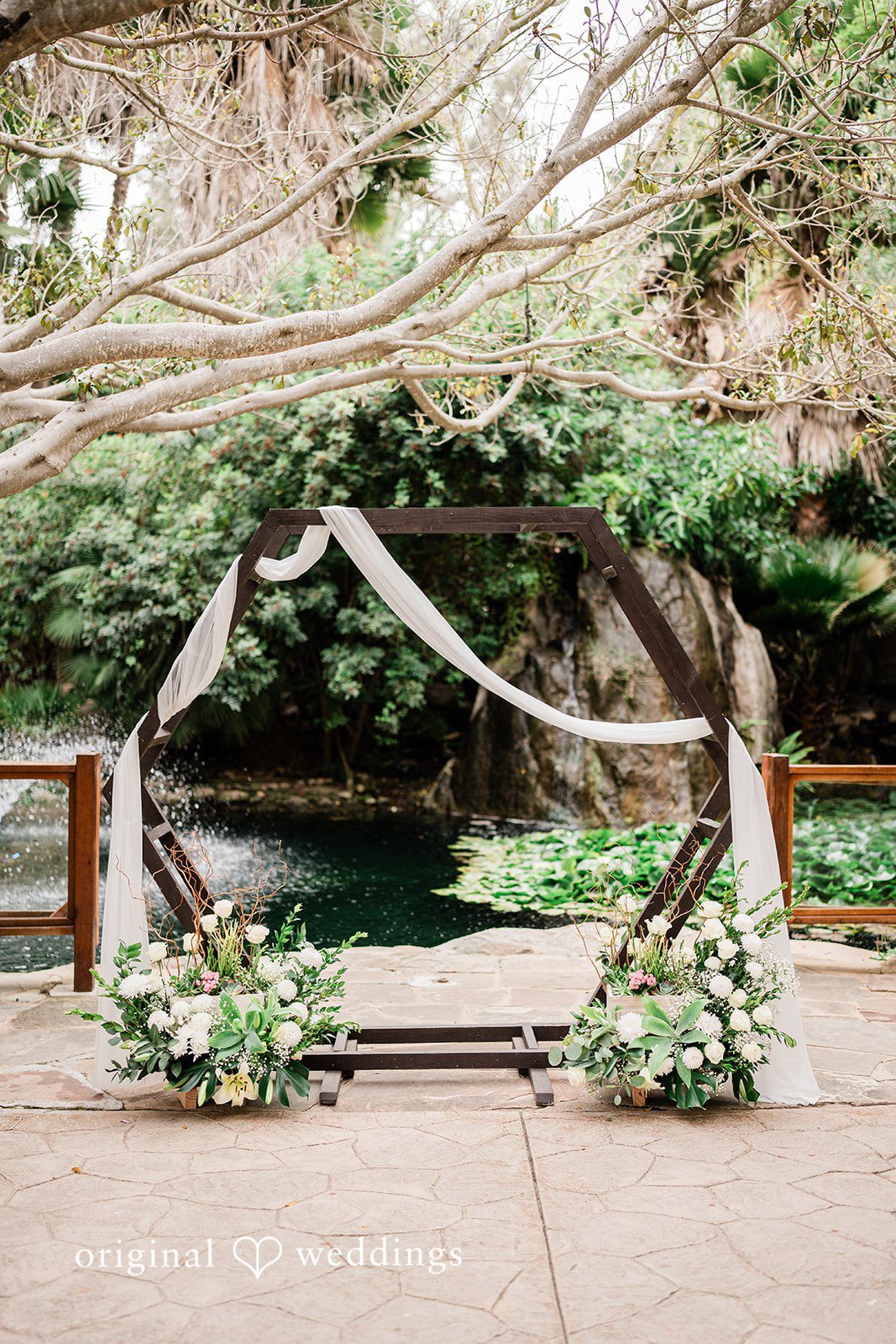 Mae + Nicholas Floral ceremony arch with pond backdrop and elegant white arrangements.