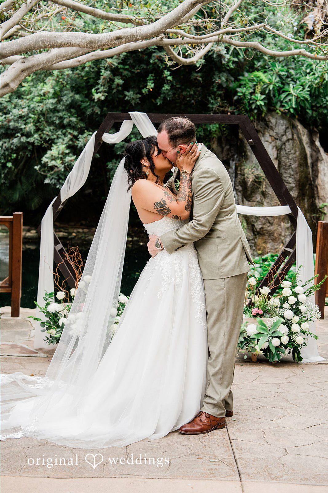 Mae + Nicholas Bride and groom sharing their first kiss under Botanica’s garden altar.