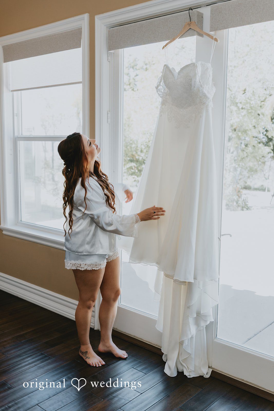 Bride admiring her beautiful white wedding gown
