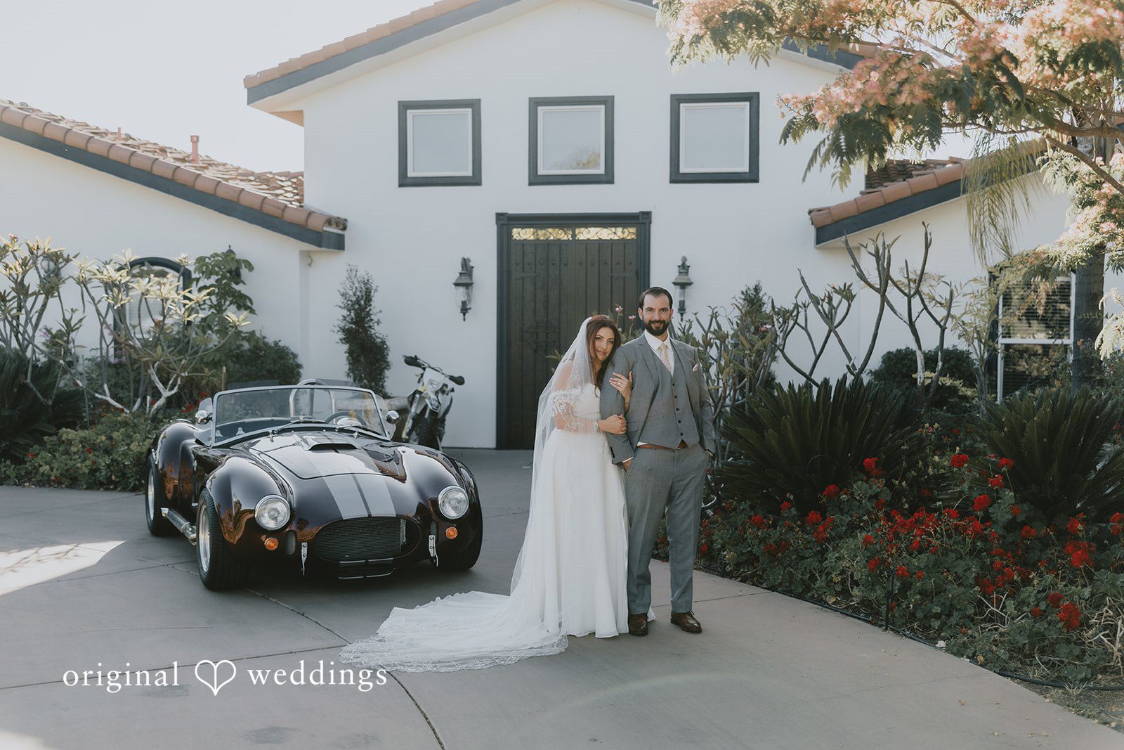 Lovely picture of couple beside a car and bike