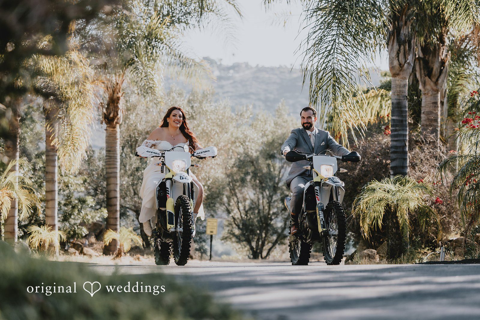 Bride and groom posing while riding bikes