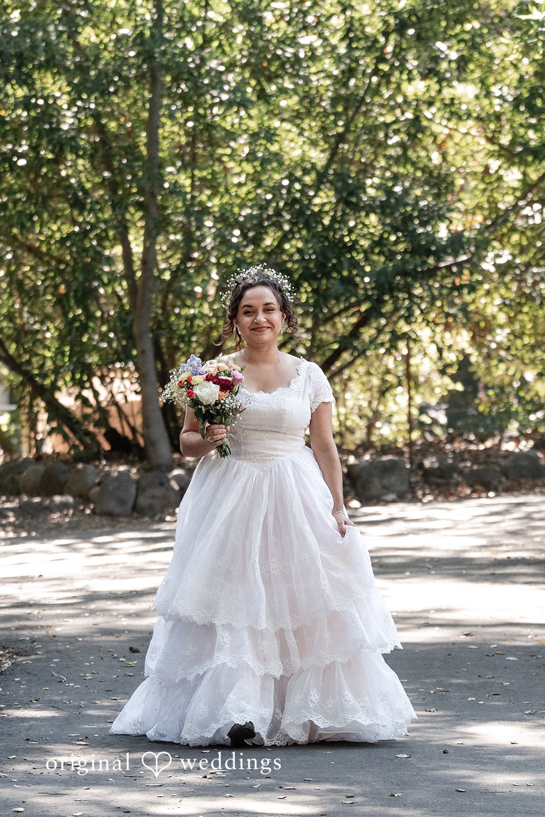 Keely + Sam Stunning portrait of bride at Camp Bartlett, smiling and holding bouquets