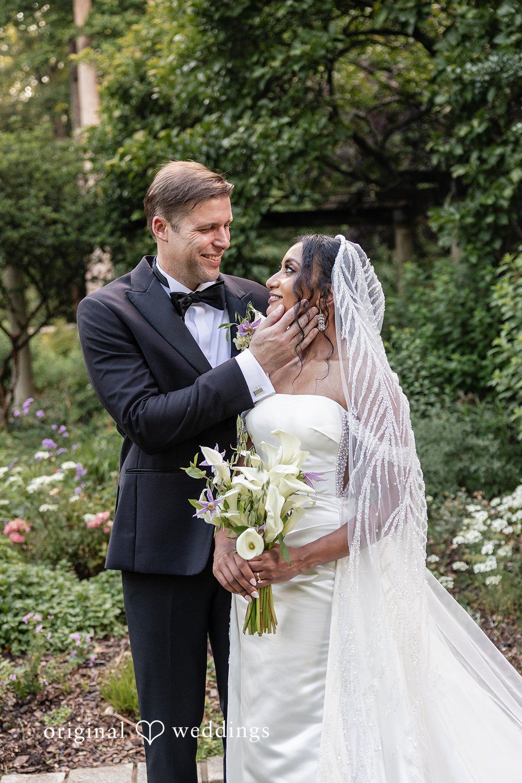 Groom gently touching bride’s face during romantic portrait session.