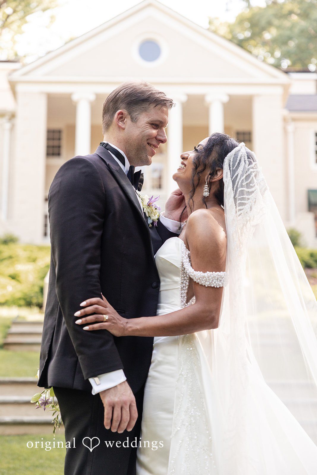 Bride and groom smile at each other during a romantic portrait session at Cater at Woolford.