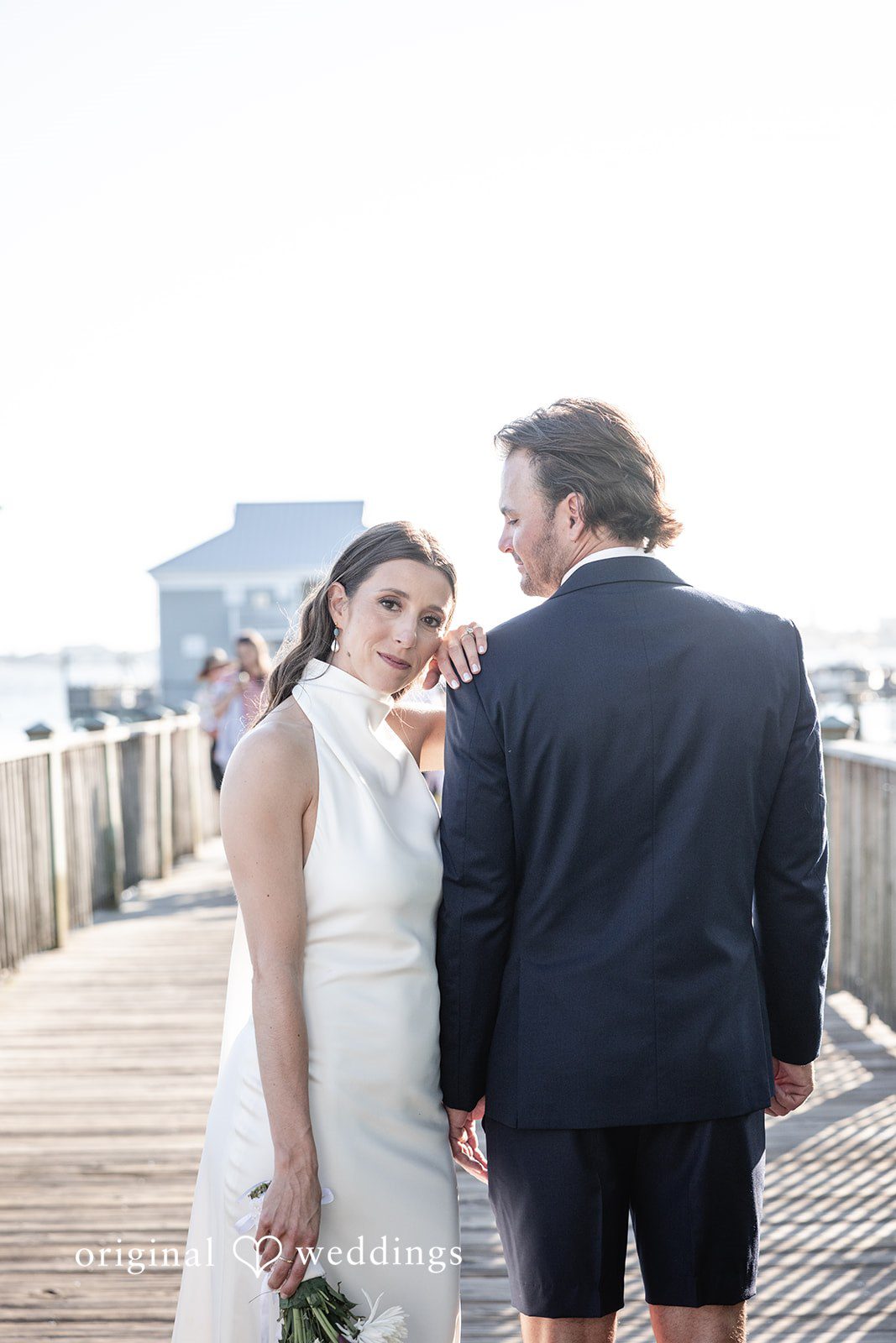 Kellie + AJ Bride and groom posing together by the water on the dock