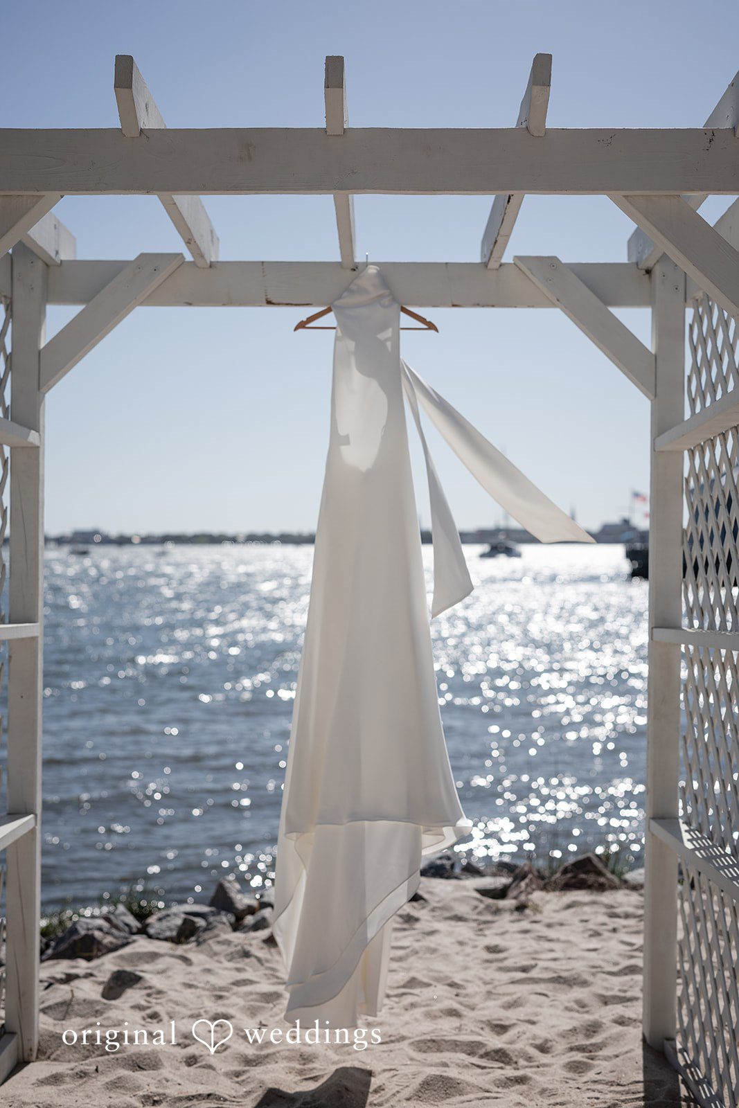 Kellie + AJ Wedding dress hanging on the beach before the ceremony