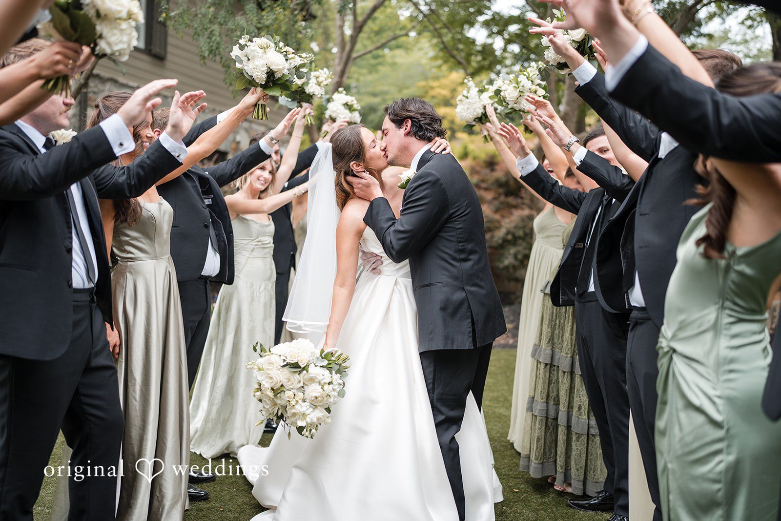 Megan + Grant The couple shares a kiss with cheers from their bridal party