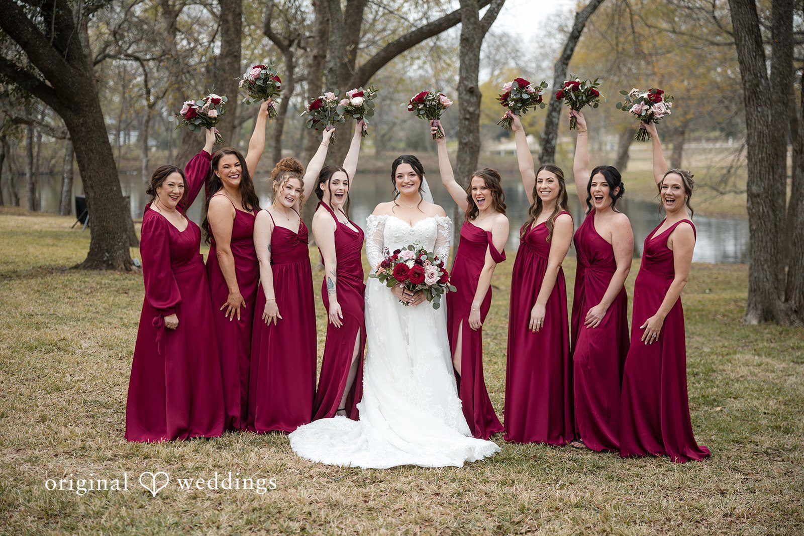 Natalie + Dakin Bride in a white gown posing with bridesmaids wearing dark red dresses.