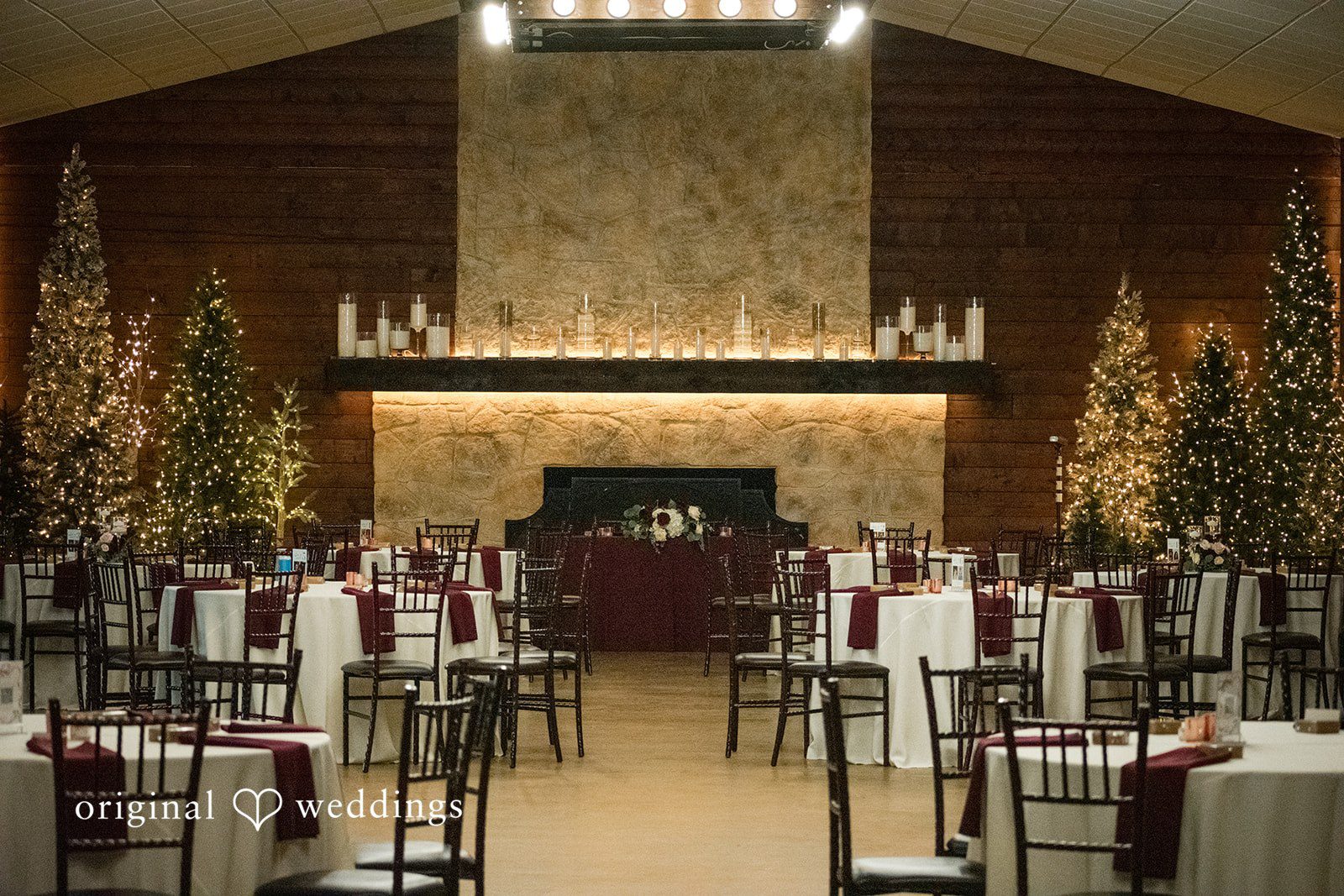 Natalie + Dakin Wedding reception hall with decorated round tables, chairs, and warm lighting.