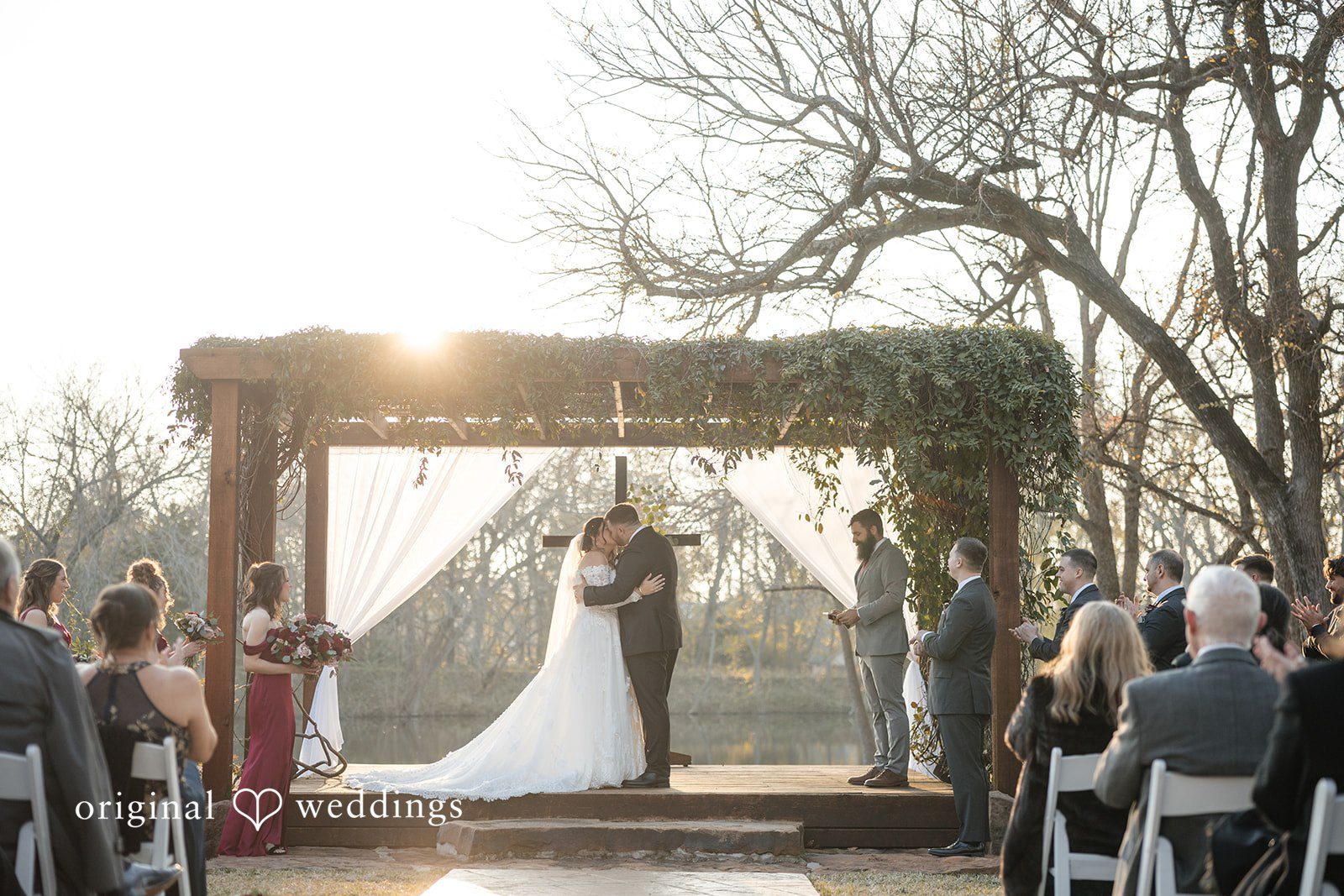 Natalie + Dakin Bride and groom sharing a kiss at the altar during their wedding ceremony.