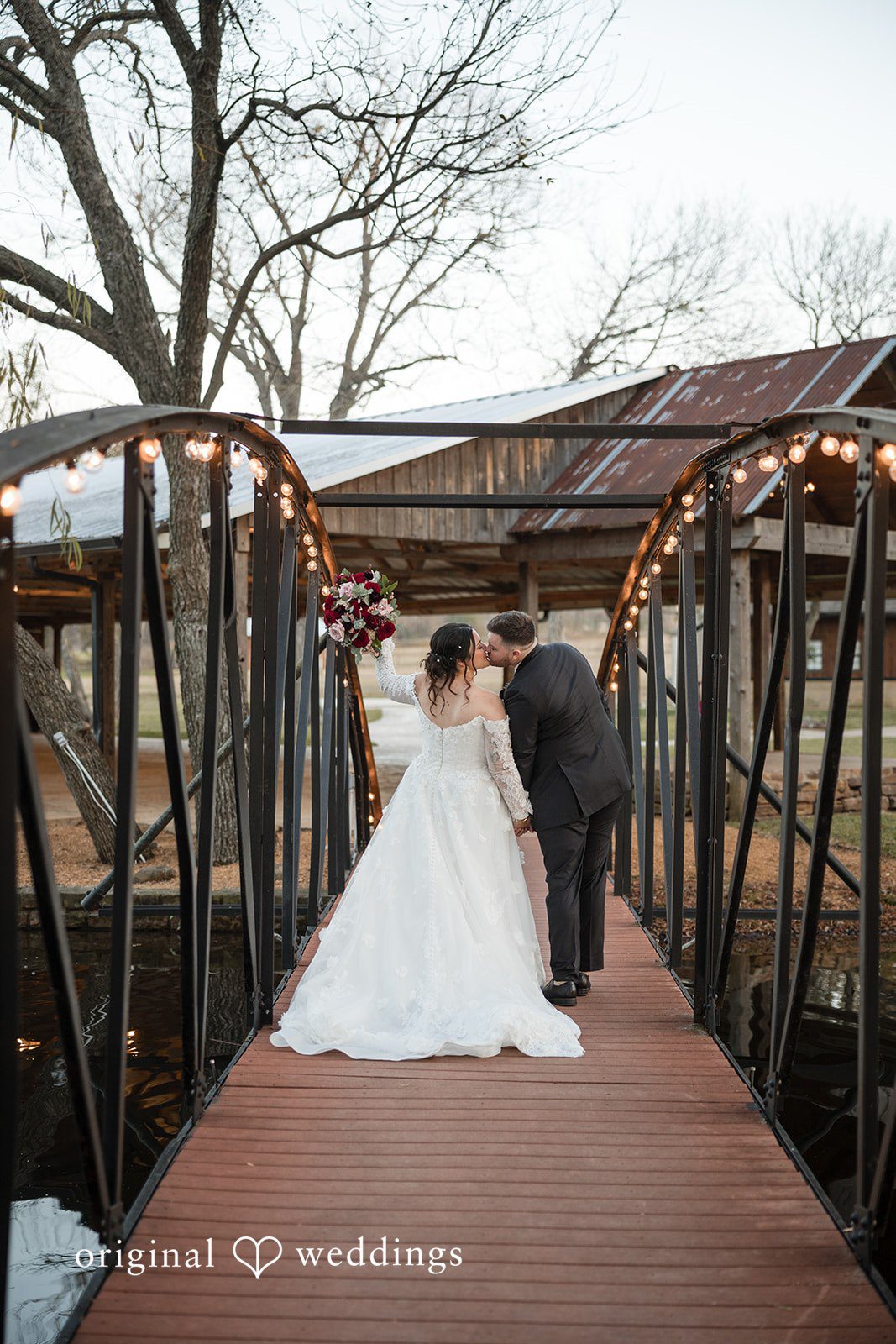 Natalie + Dakin Bride in a full wedding gown walking across a long wooden bridge.