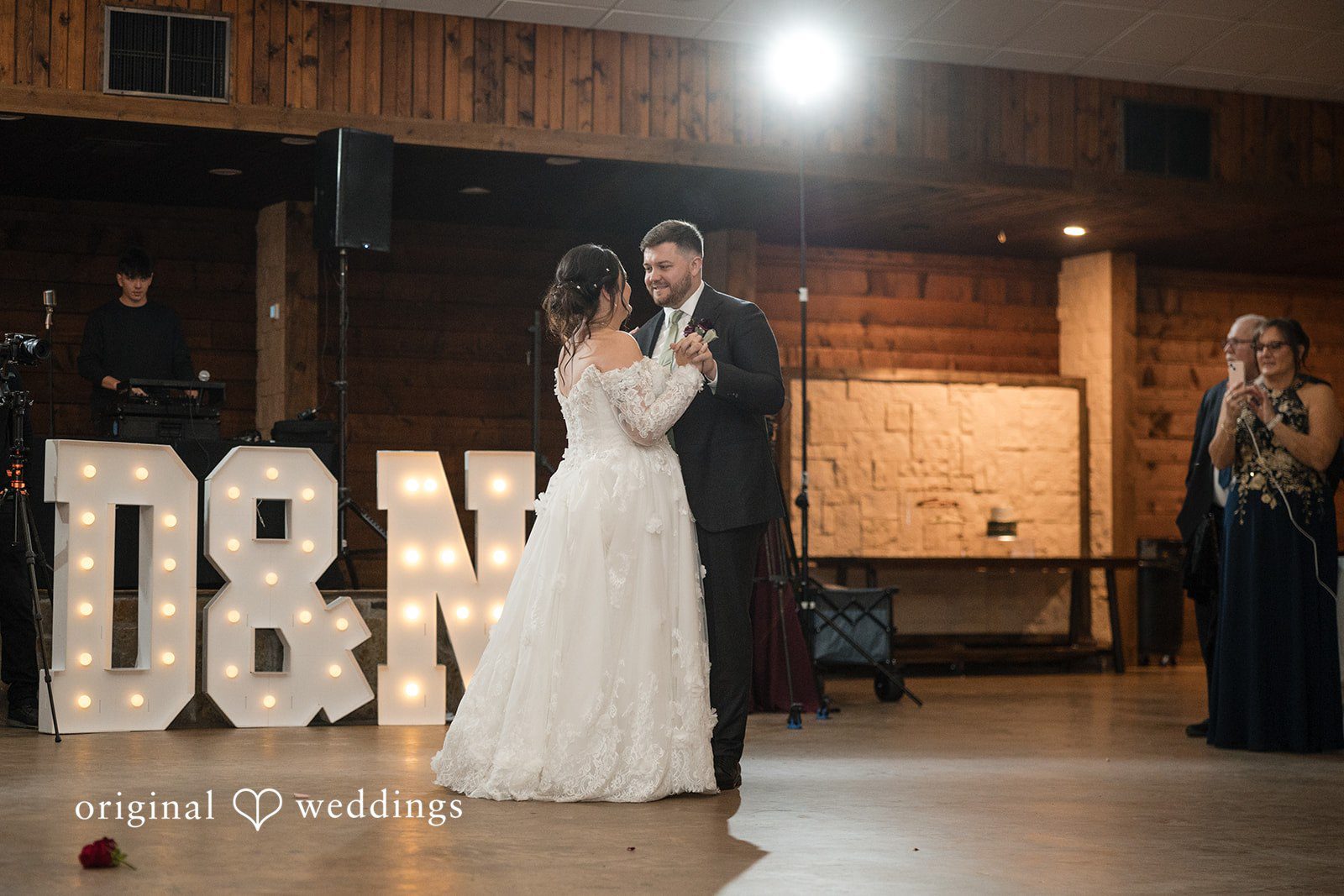Natalie + Dakin Bride and groom sharing a dance near large illuminated letters.