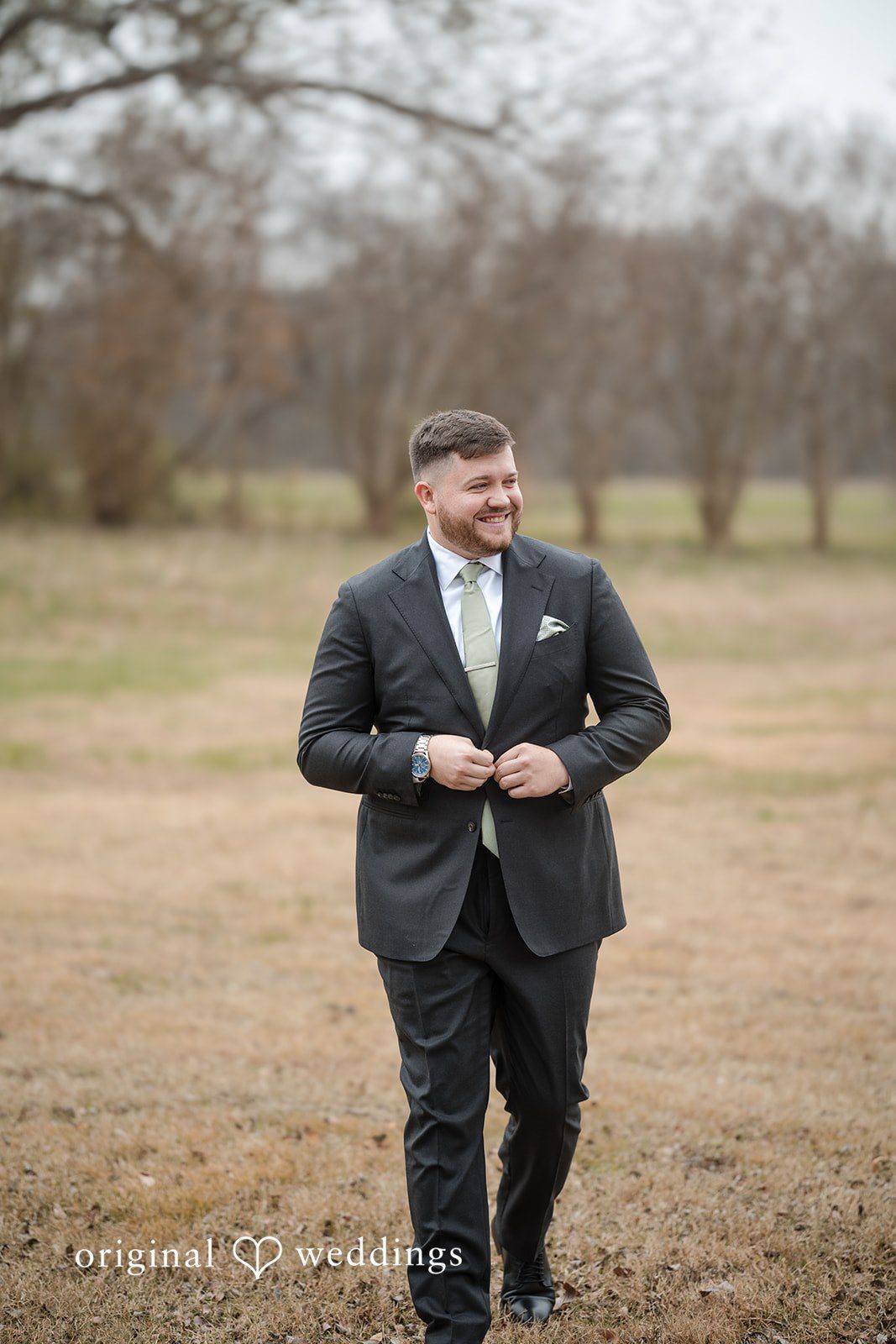 Natalie + Dakin Groom walking through a grassy field at Cross Creek Ranch.