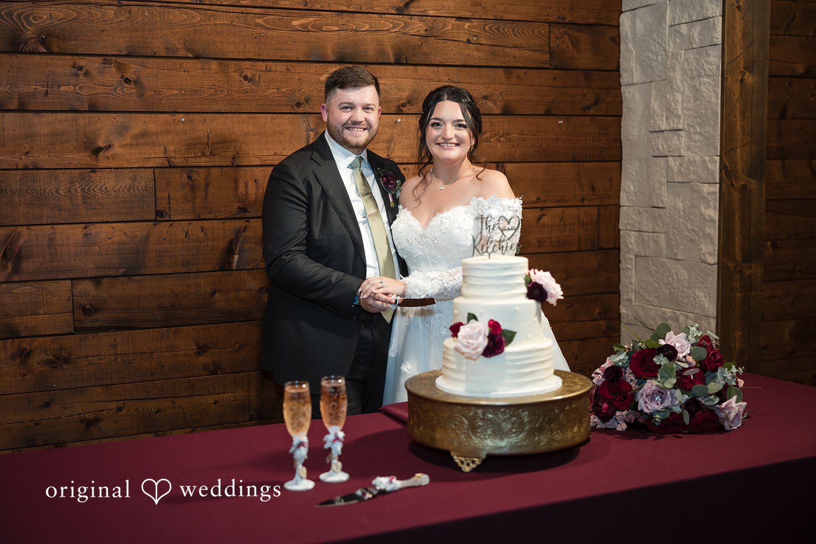 Natalie + Dakin Bride and groom standing together behind a multi-tiered wedding cake.
