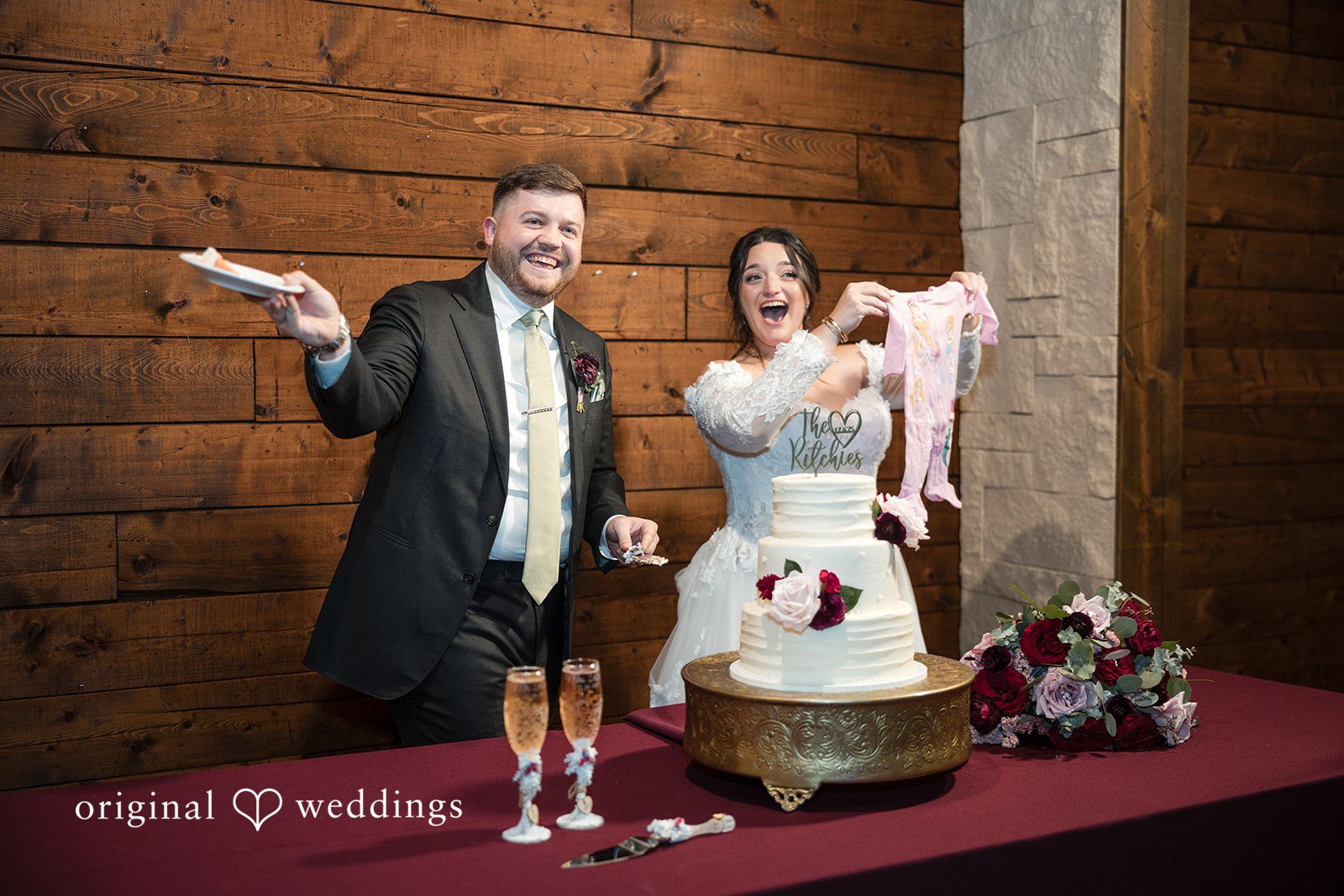 Natalie + Dakin Bride and groom celebrating excitedly behind their wedding cake table.