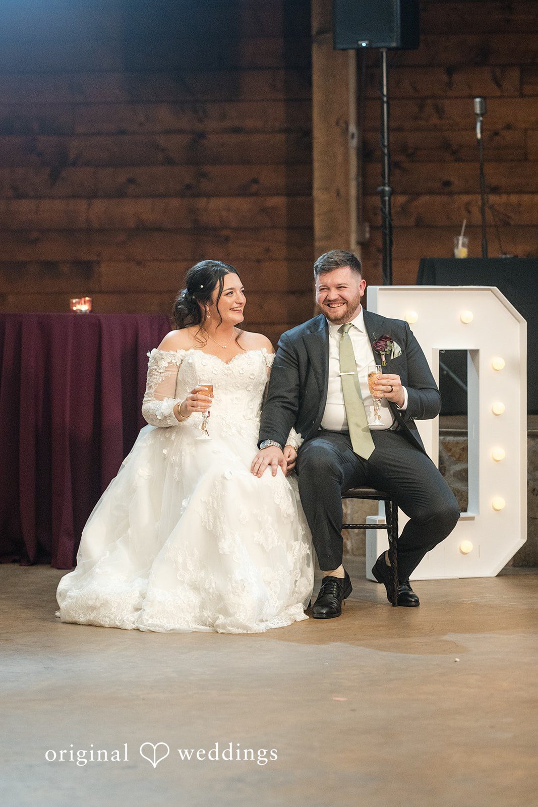 Natalie + Dakin Bride and groom laughing while sitting together at a reception table.
