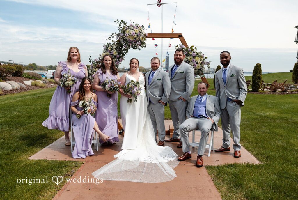 Katelyn + Bradley Wedding party portrait under the floral arch at DoubleTree by Hilton Port Huron captured by Detroit wedding photographers from Original Weddings.
