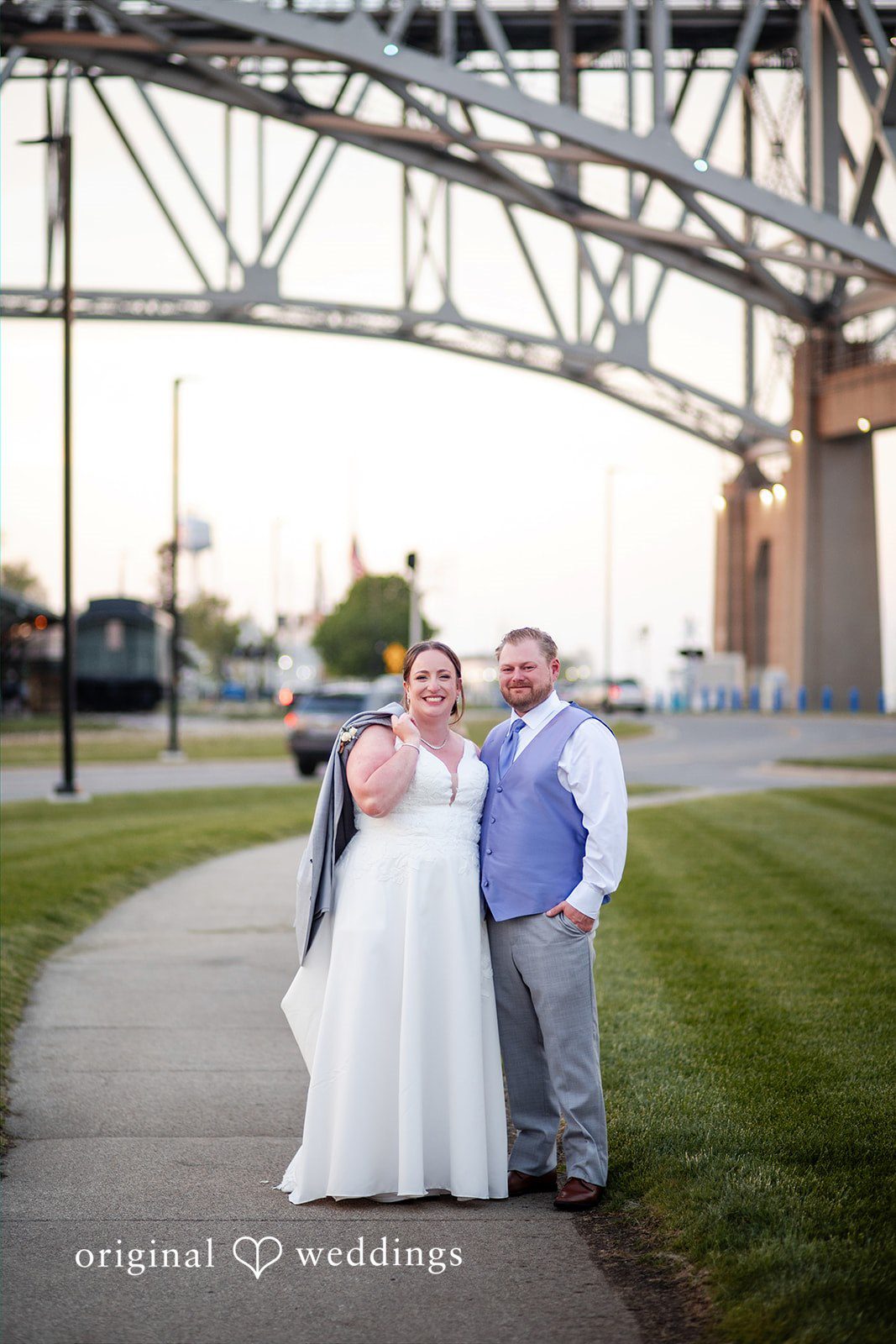 Katelyn + Bradley Bride and groom posing together beneath Blue Water Bridge at DoubleTree by Hilton Port Huron.