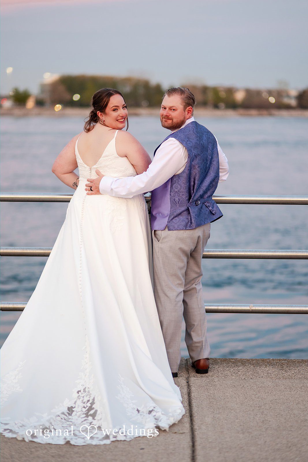 Katelyn + Bradley Bride and groom smiling back at the camera during waterfront portraits at DoubleTree by Hilton Port Huron.