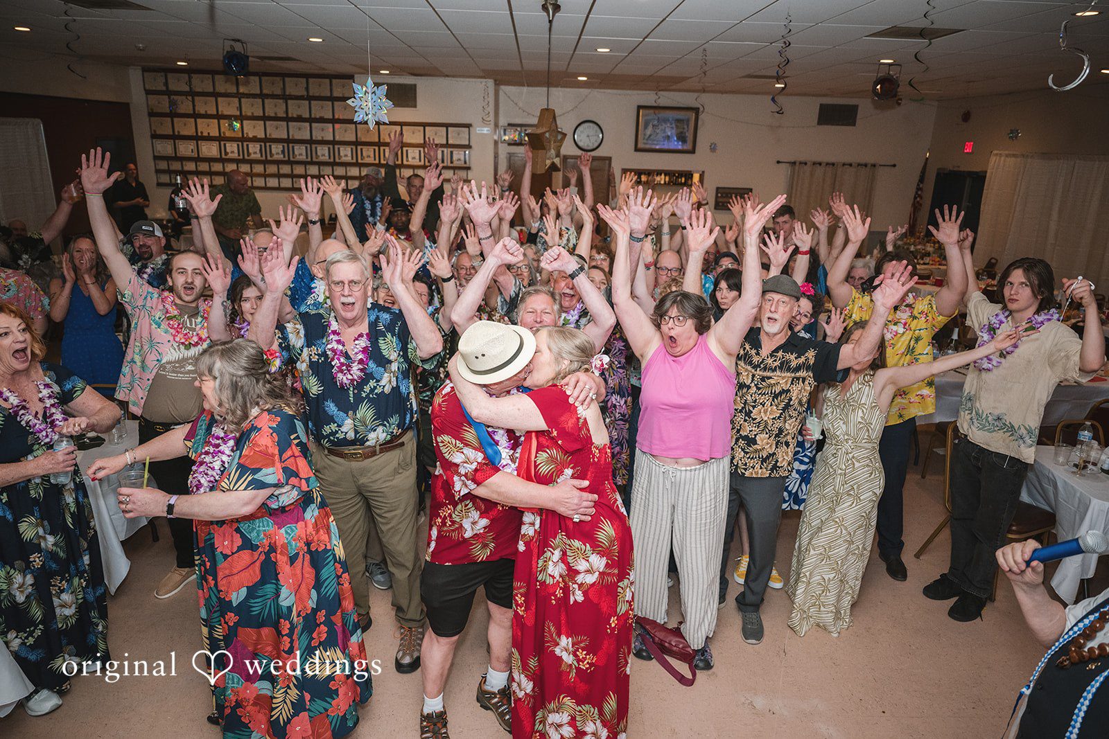 Bride and groom celebrating with guests on the dance floor at the reception