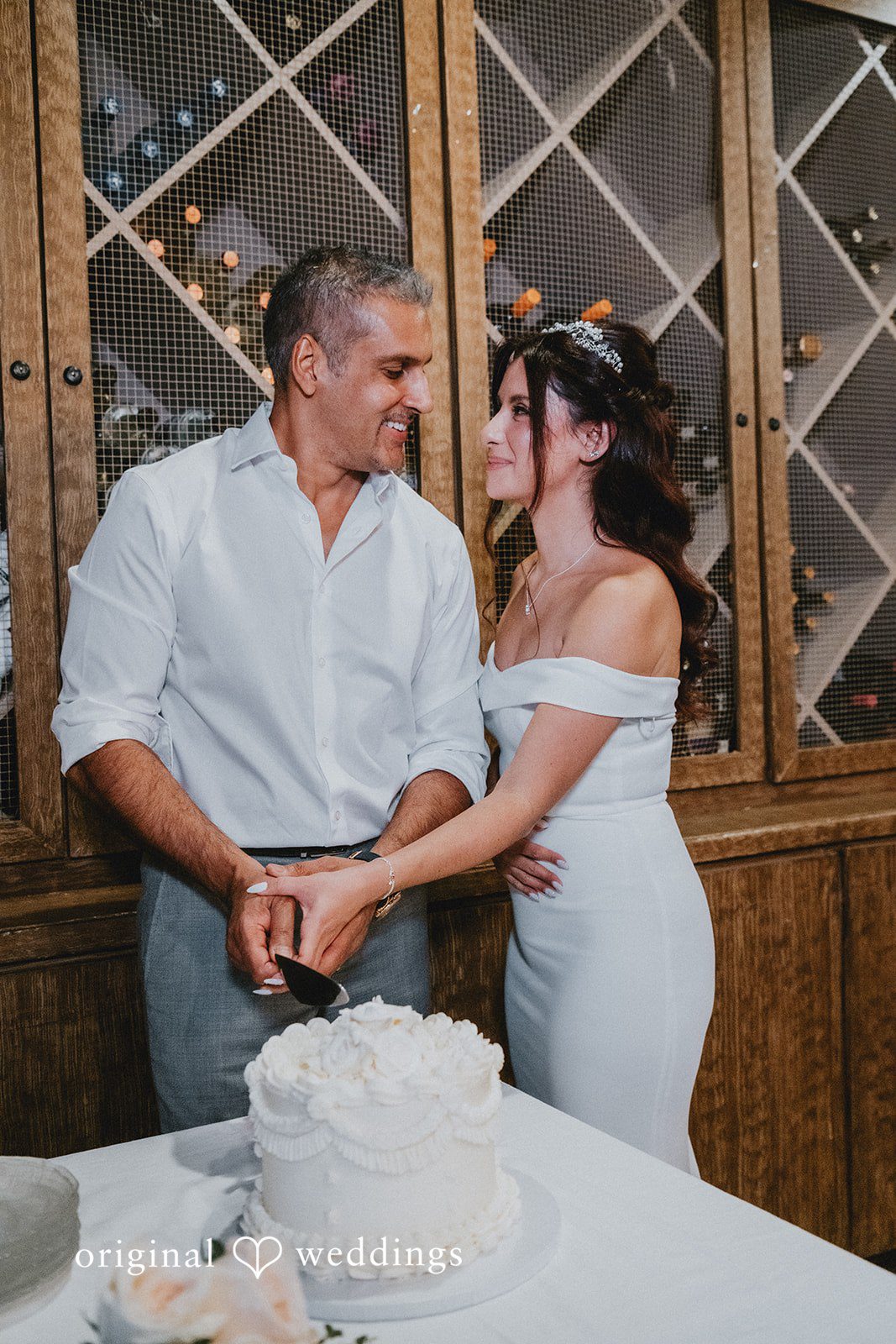 Sunny + Erika Couple smiling while cutting the wedding cake