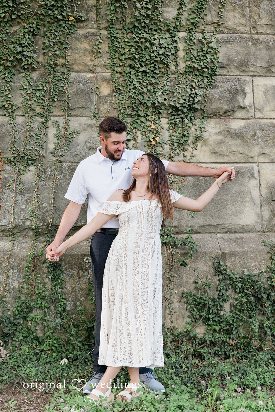 Morgan + Griffin Couple holding hands in playful engagement pose