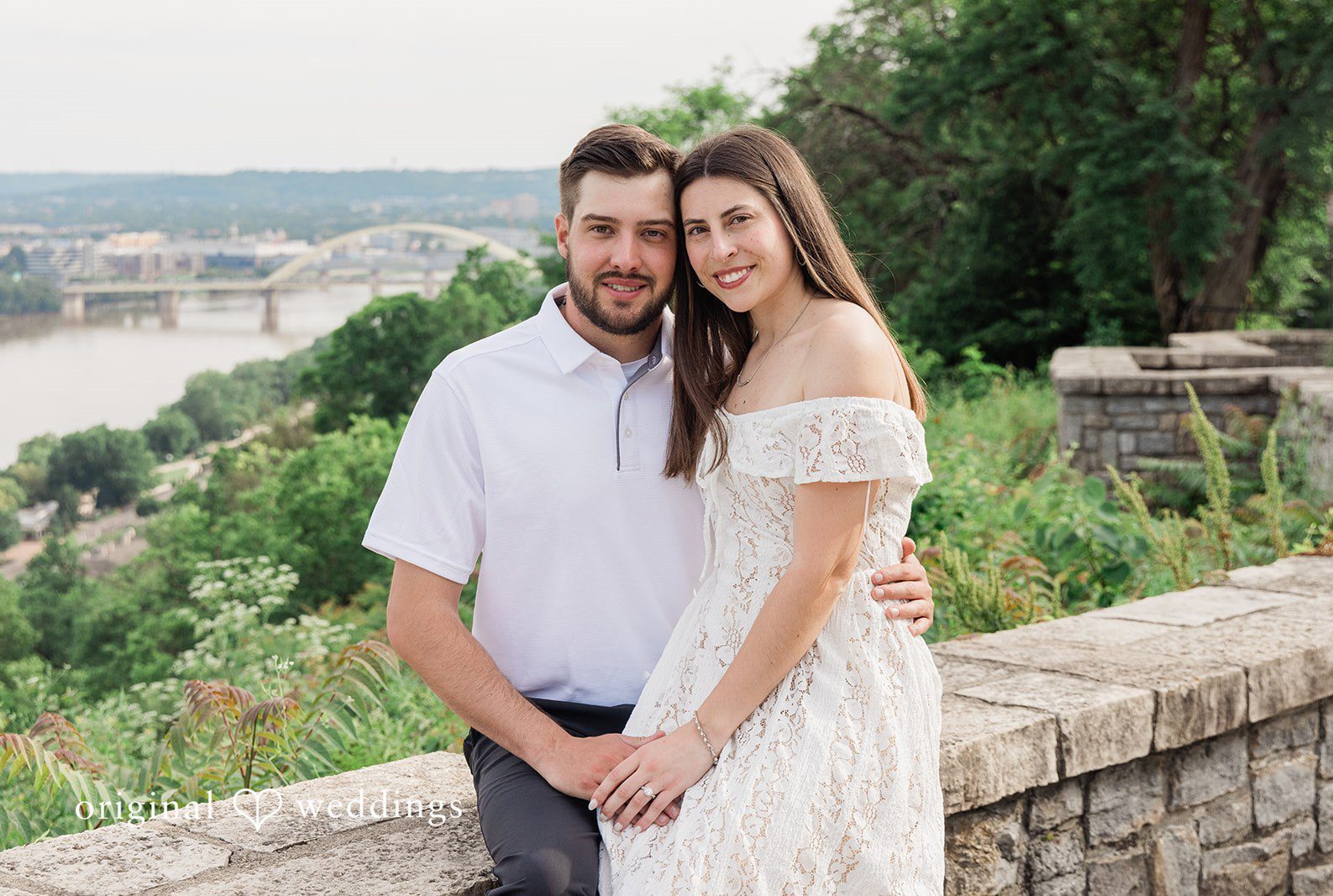 Couple sitting together near stone wall at Eden Park captured by Cincinnati engagement photographers from Original Weddings