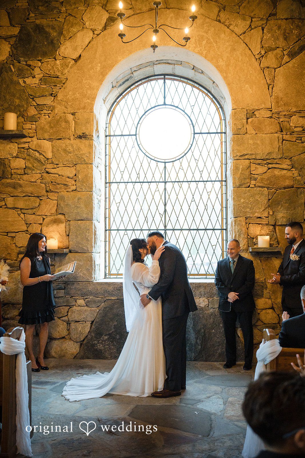Carolyn + Robert Bride and groom sharing a kiss at the altar in a church.