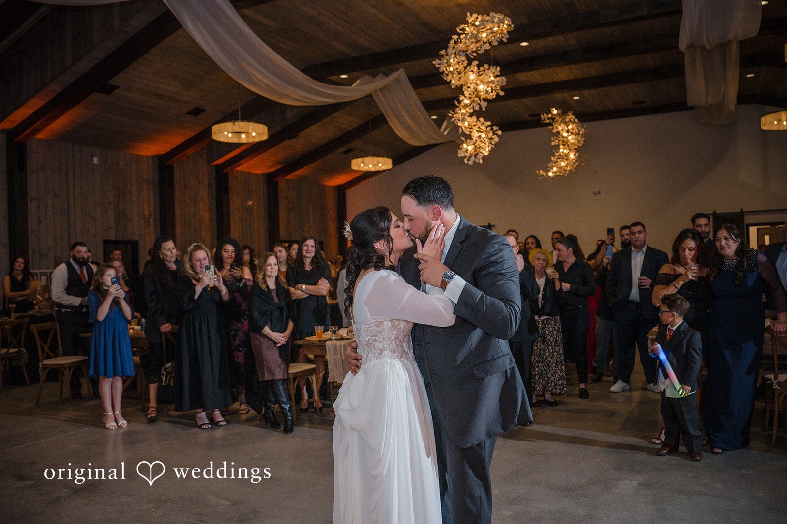 Carolyn + Robert Newlywed couple dancing together surrounded by guests.