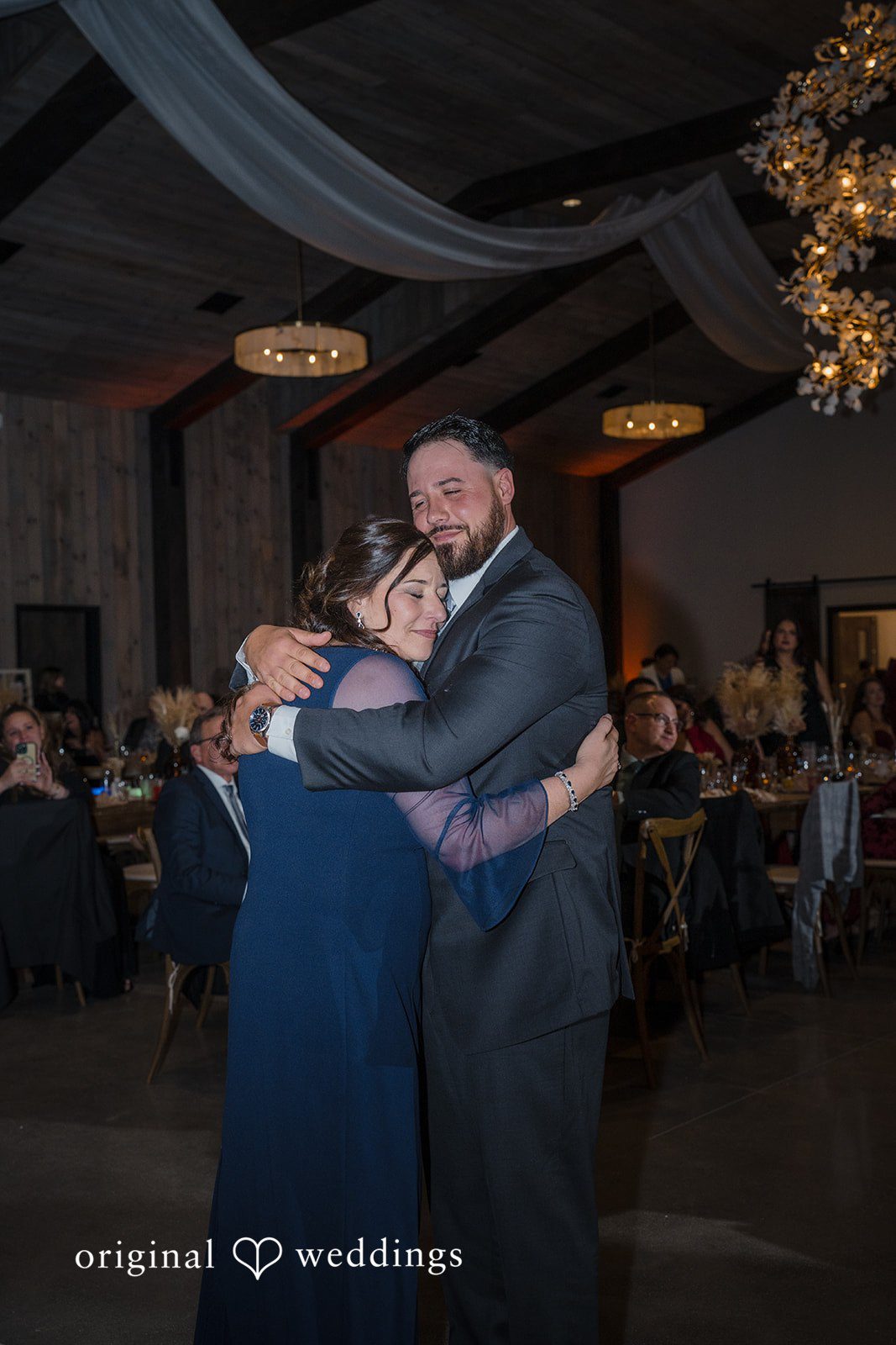 Carolyn + Robert Two guests sharing a warm embrace on the dance floor.