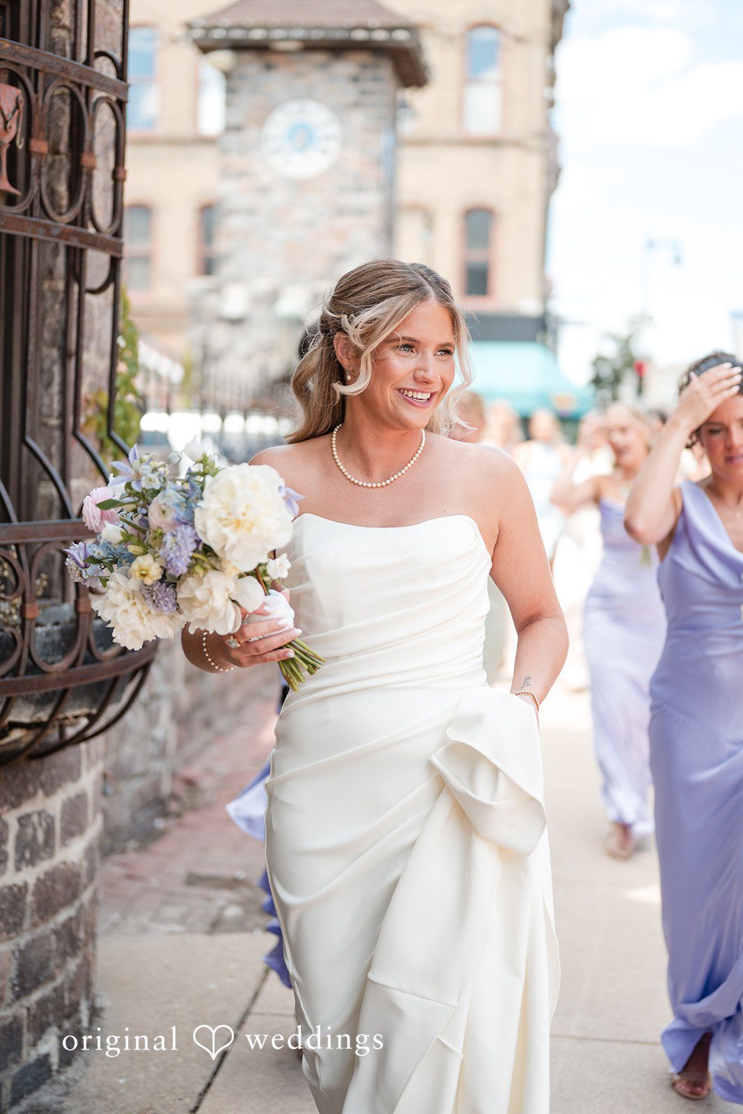Bride walking through downtown with bouquet and radiant smile before the wedding ceremony