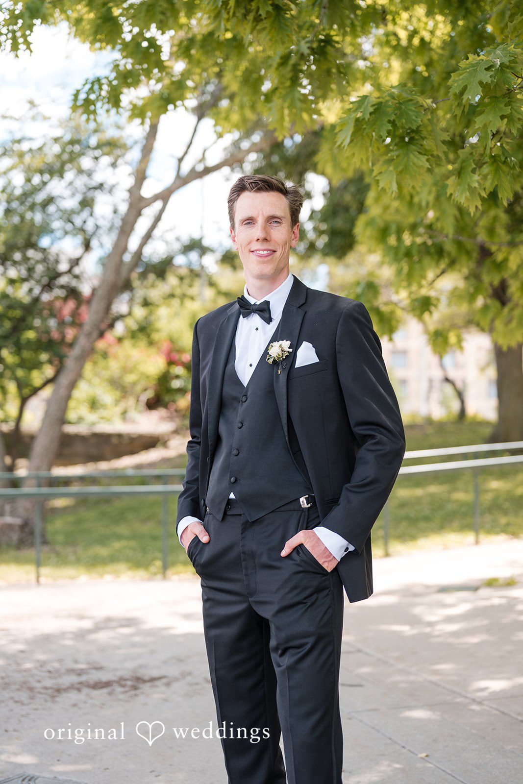 Groom portrait outdoors in classic black tuxedo with bow tie before the ceremony
