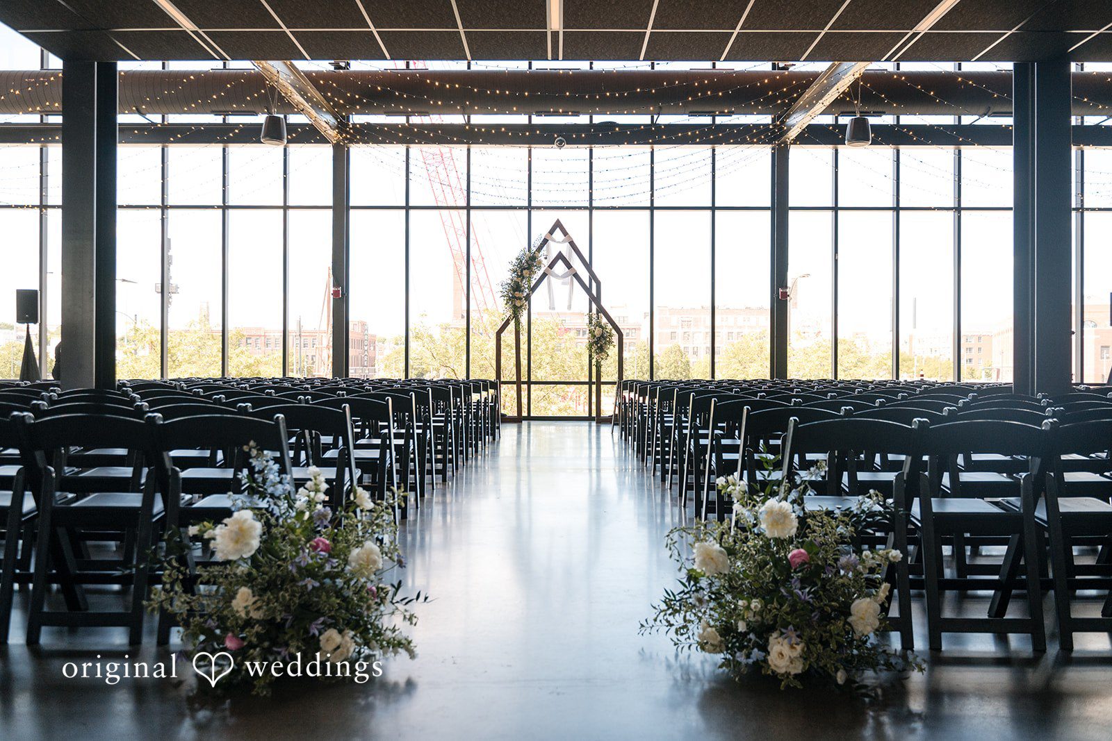 Wedding ceremony setup at Gather at Deer District with floral aisle arrangements and geometric altar backdrop