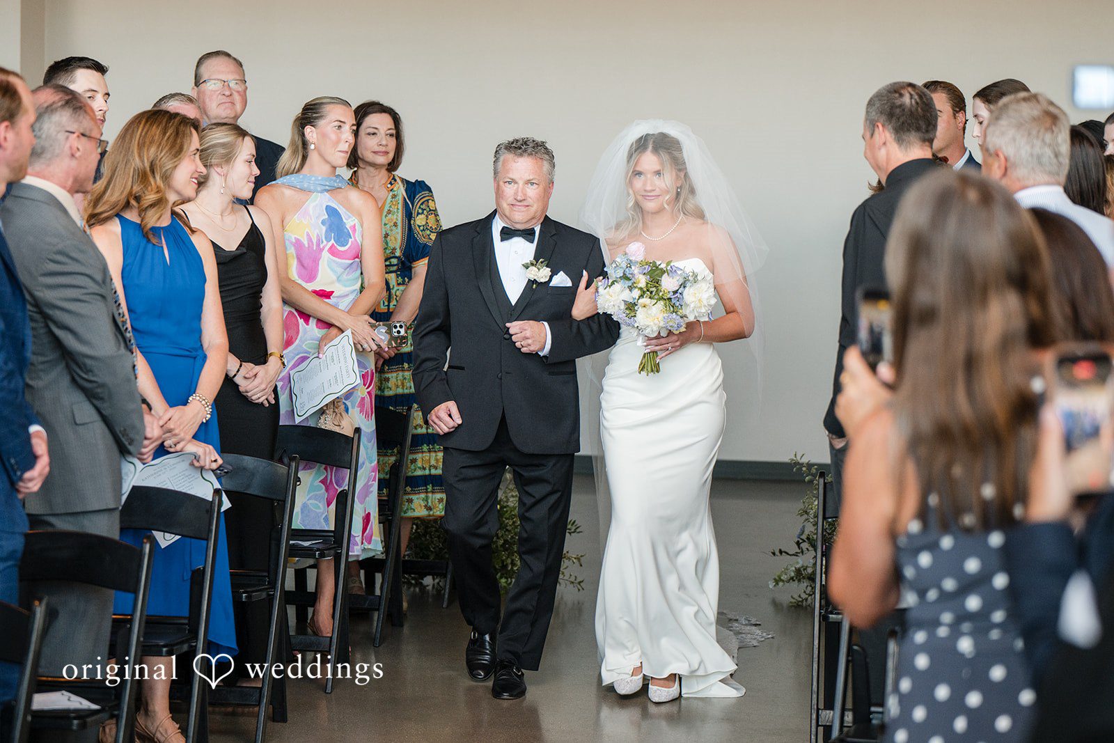 Bride walking down the aisle with her father during emotional indoor ceremony entrance
