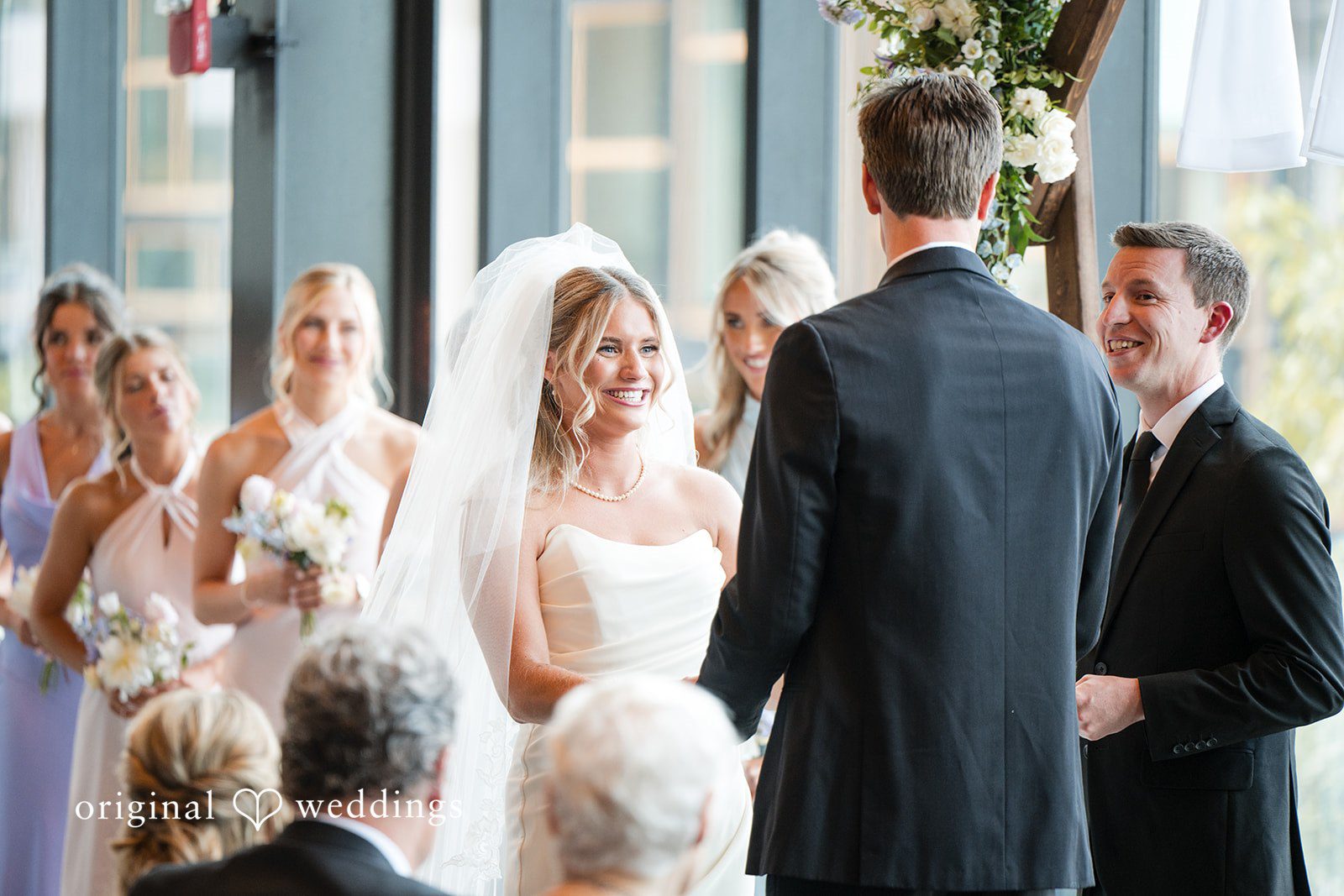Bride and groom smiling during heartfelt indoor wedding ceremony at the altar