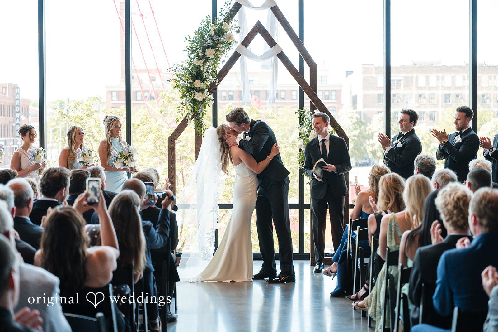 Newlyweds sharing first kiss at Gather at Deer District as guests applaud