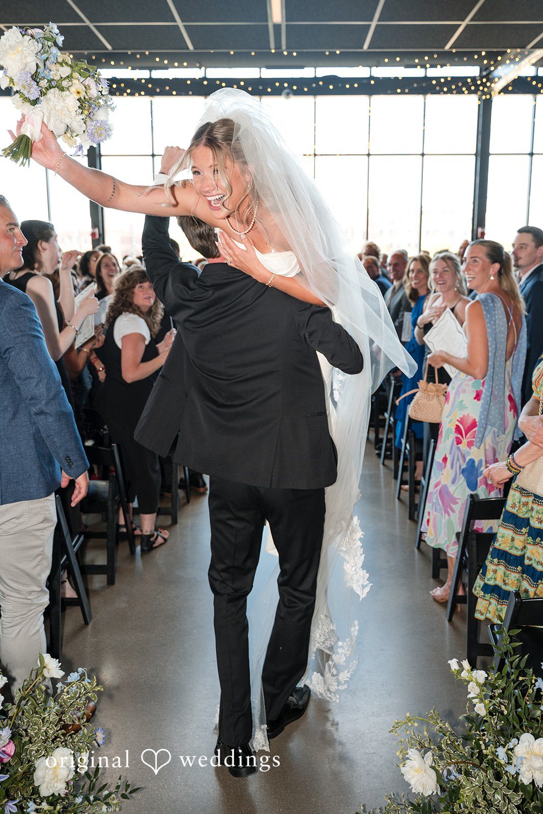 Groom lifting bride in celebration at Gather at Deer District after the ceremony