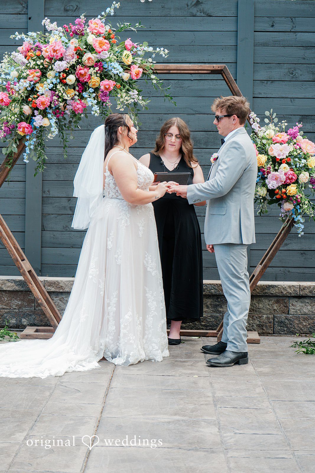 Janissa + Josh Lovely picture of couple listening to the priest, hands in hands at Gather at the Lakes
