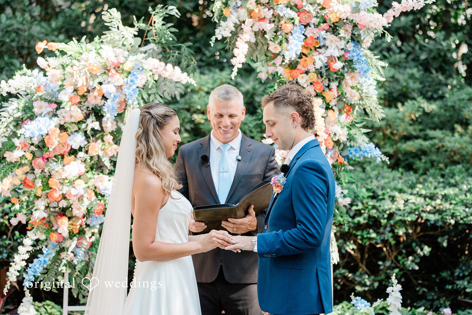 The bride puts a ring on the groom's finger
