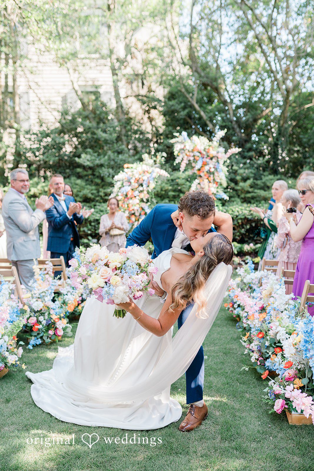 The couple shares a kiss on the aisle
